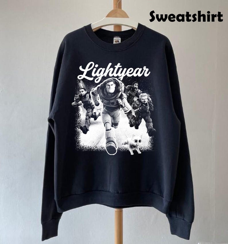 May include: Black sweatshirt featuring a graphic of Buzz Lightyear and other characters from the movie Lightyear. The word "Lightyear" is written in white script above the graphic. The word "Sweatshirt" is written in black block letters at the top.