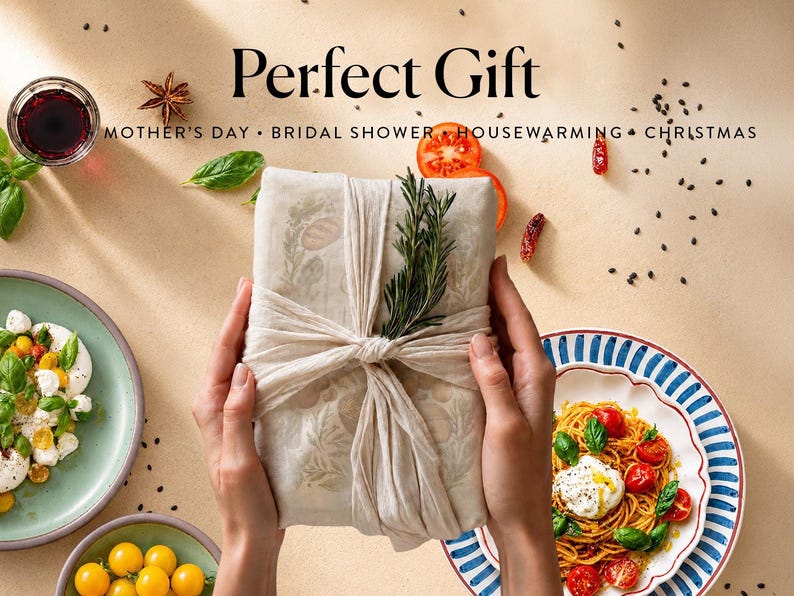 May include: A rectangular package wrapped in beige fabric with a botanical print, tied with a matching fabric strip and a sprig of fresh rosemary. The text Perfect Gift, MOTHER'S DAY, BRIDAL SHOWER, HOUSEWARMING, CHRISTMAS is printed above.
