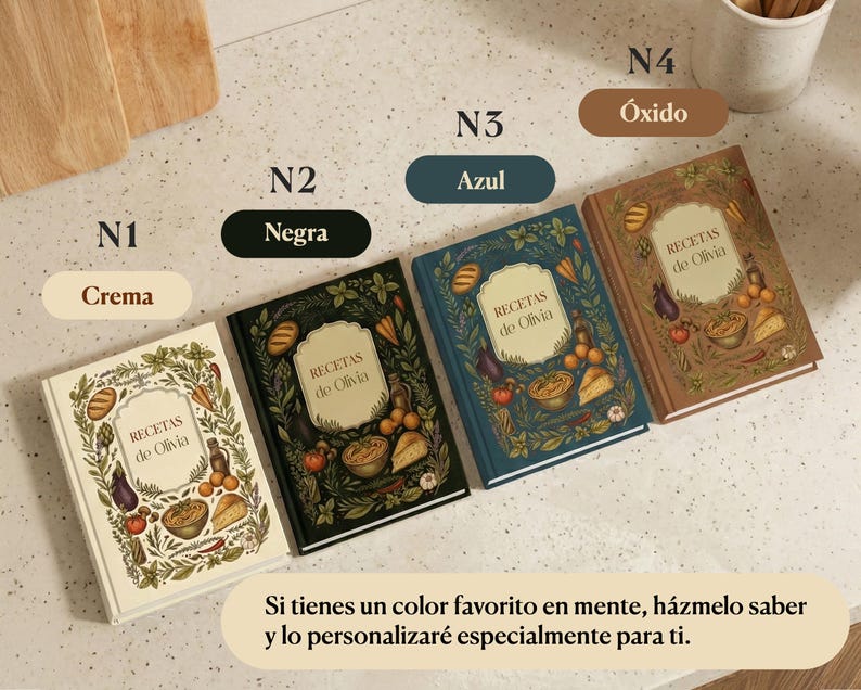 May include: Four cookbooks with the title "RECETAS de Olivia" are displayed. The covers are cream, black, blue, and rust-colored, each with a different illustration of food and foliage. The text "Si tienes un color favorito en mente, h&aacute;zmelo saber y lo personalizar&eacute; especialmente para ti" is also visible.