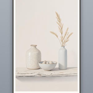 May include: A framed wall art print featuring a white crackle-glaze vase, a small white bowl containing several smooth stones, and a tall white bottle holding dried pampas grass stems. The text at the bottom reads MULTIPLE SIZES · INCHES & CM.