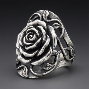 May include: A silver ring featuring a prominent, three-dimensional rose bloom as the centrepiece. The band is crafted with an openwork design, incorporating intricate, sculpted vine and leaf motifs that extend from the central rose flower.