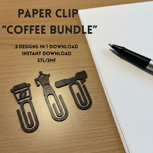 Può includere: Tre graffette nere a forma di oggetti legati al caffè, tra cui una tazza, una caffettiera e una macchina per il caffè. Il testo "PAPER CLIP COFFEE BUNDLE" è visibile. Una penna e un blocco note sono presenti.