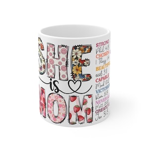 Puede incluir: Una taza de cerámica blanca con un asa negra y el texto "But First, Coffee" en negrita negra. La taza se encuentra sobre un fondo borroso, sugiriendo un ambiente acogedor.