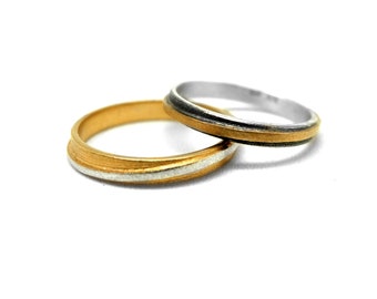 pair of silver bands, black silver gold rings, stackable rings