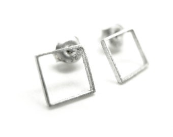 May include: A pair of silver square stud earrings with a brushed finish.