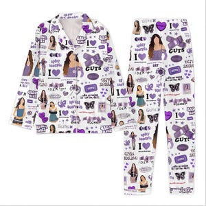 Peut inclure: Ensemble de pyjama blanc avec un haut boutonné et un pantalon assorti. L'ensemble est orné de graphiques violets, notamment des cœurs, des papillons et du texte "GUTS" et "spicy scorpio".