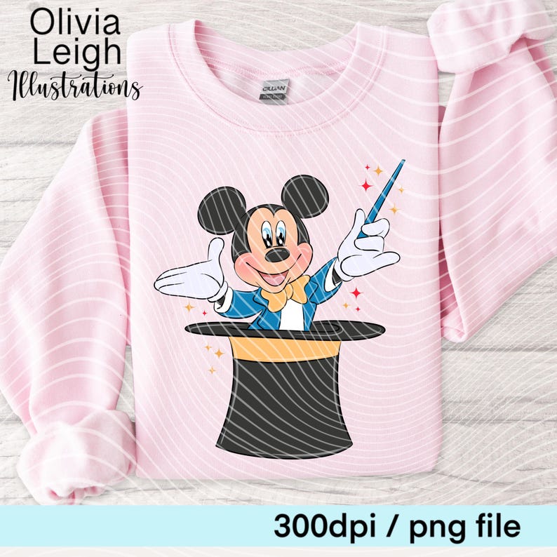 May include: Pale pink sweatshirt with a cartoon Mickey Mouse magician design. Mickey is emerging from a black top hat with a yellow band, holding a blue wand. The text reads "Olivia Leigh Illustrations" and "300dpi / png file".
