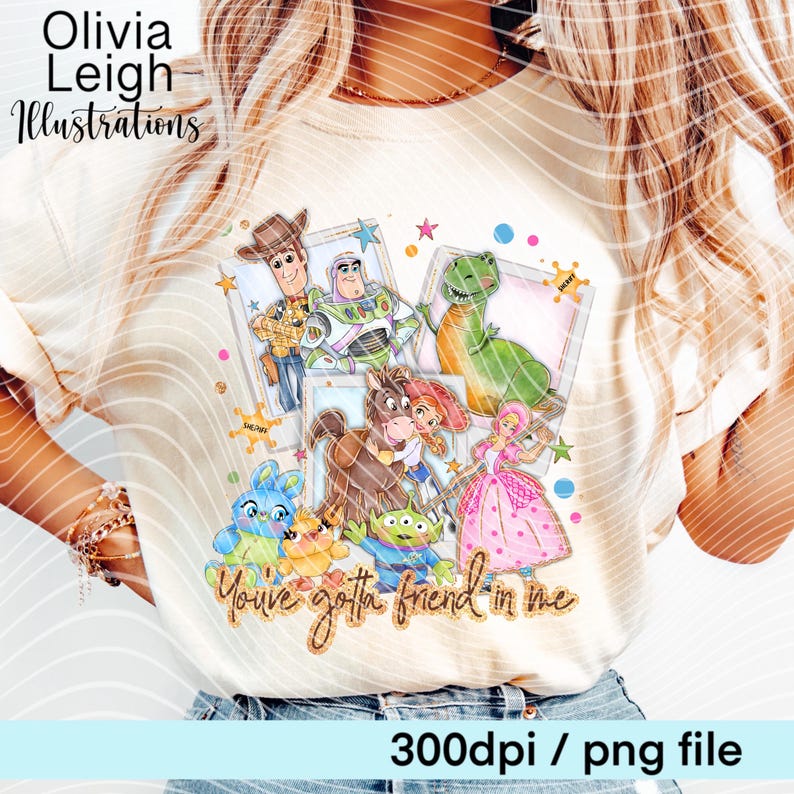 Op de afbeelding: Cr&egrave;mekleurig T-shirt met een kleurrijke afbeelding van Toy Story-personages. Het ontwerp bevat Woody, Buzz Lightyear, Rex en anderen, met de tekst "You've gotta friend in me". Het shirt heeft ook de tekst "Olivia Leigh Illustrations".