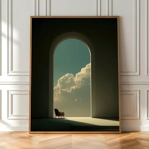 May include: A framed art print depicting an arched doorway leading to a bright sky with white clouds. A chair is positioned in the doorway. The artwork is displayed on a wooden floor.