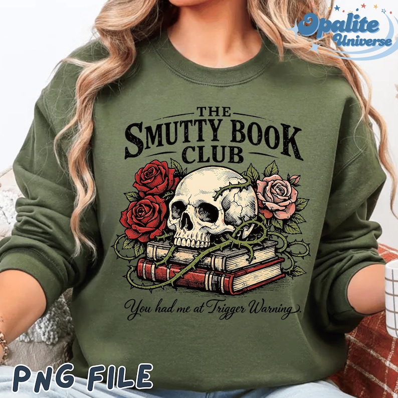 Puede incluir: Sudadera verde oliva con un dise&ntilde;o gr&aacute;fico que presenta una calavera, rosas rojas y rosas, y una pila de libros. El texto dice "THE SMUTTY BOOK CLUB" y "You had me at Trigger Warning."