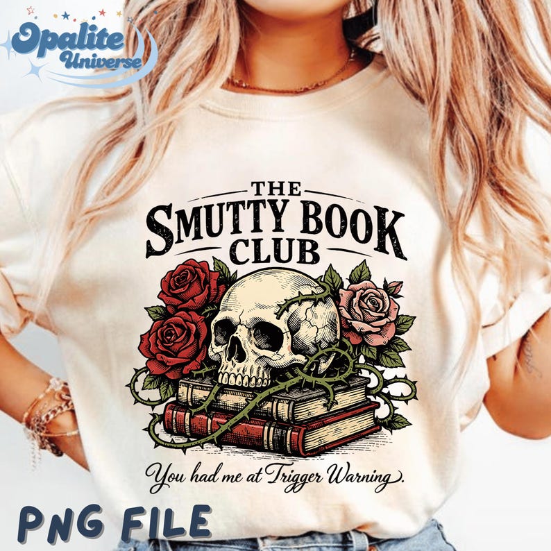 Puede incluir: Camiseta color crema con un dise&ntilde;o de calavera sobre libros, rodeada de rosas rojas y rosas y enredaderas espinosas. El texto dice "THE SMUTTY BOOK CLUB" y "You had me at Trigger Warning".