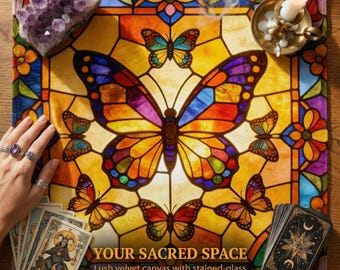 Könnte beinhalten: Eine quadratische Samtmatte mit einem Buntglas-Muster, das einen großen zentralen Schmetterling, kleinere Schmetterlinge und Blumenmotive zeigt. Der Text lautet YOUR SACRED SPACE. Enthält eine Amethyststufe, eine Kerze und Tarotkarten.