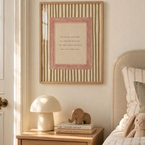 May include: A framed wall art print featuring vertical olive green stripes and a central rectangular pink border. The text reads: You are my little light, my warm and quiet day, the kind of gentle sunshine that never fades away.