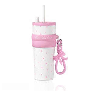 May include: A white tumbler with pink polka dots, a pink lid, and a white straw. A pink silicone band wraps around the center with the text Happy Supply Chain. A pink silicone bow charm hangs from a metal ring attached to the silicone band.