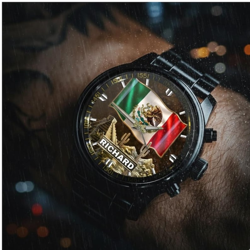 May include: Black wristwatch featuring the Mexican flag on the watch face. The watch face also displays the name "RICHARD". The watch has a black metal band and a black bezel. The watch hands are silver.