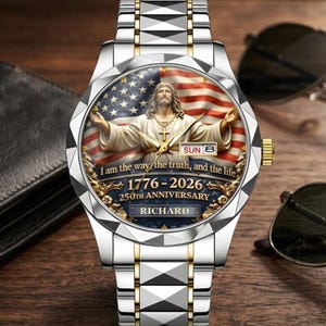 May include: A silver and gold wristwatch with a detailed face featuring an image of Jesus Christ with an American flag background. The watch face includes the text "I am the way, the truth, and the life" and "1776-2026 250th Anniversary".