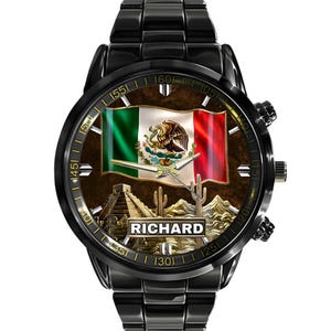 May include: Black wristwatch featuring the Mexican flag, a pyramid, and desert landscape on the face. The watch has a black band and the name "RICHARD" is displayed on the watch face.