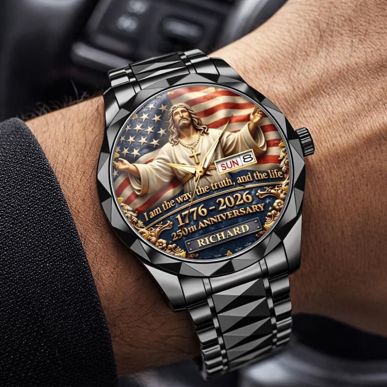 May include: A black stainless steel wristwatch with a detailed face featuring an image of Jesus with the American flag in the background. The watch face includes the text "I am the way, the truth, and the life" and "1776-2026 250th Anniversary RICHARD".