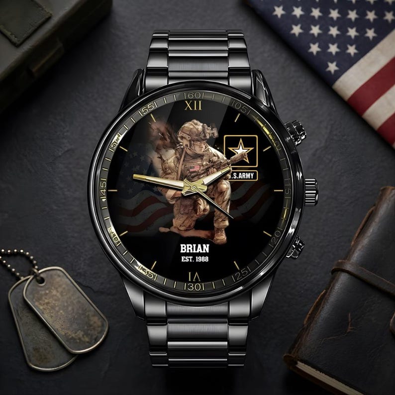 Puede incluir: Reloj de pulsera negro con una esfera detallada que presenta un soldado, el logotipo del ej&eacute;rcito estadounidense y un dise&ntilde;o de la bandera estadounidense. El reloj tiene una correa de metal negro y el nombre "BRIAN" y el a&ntilde;o "EST. 1988" est&aacute;n impresos en la esfera.