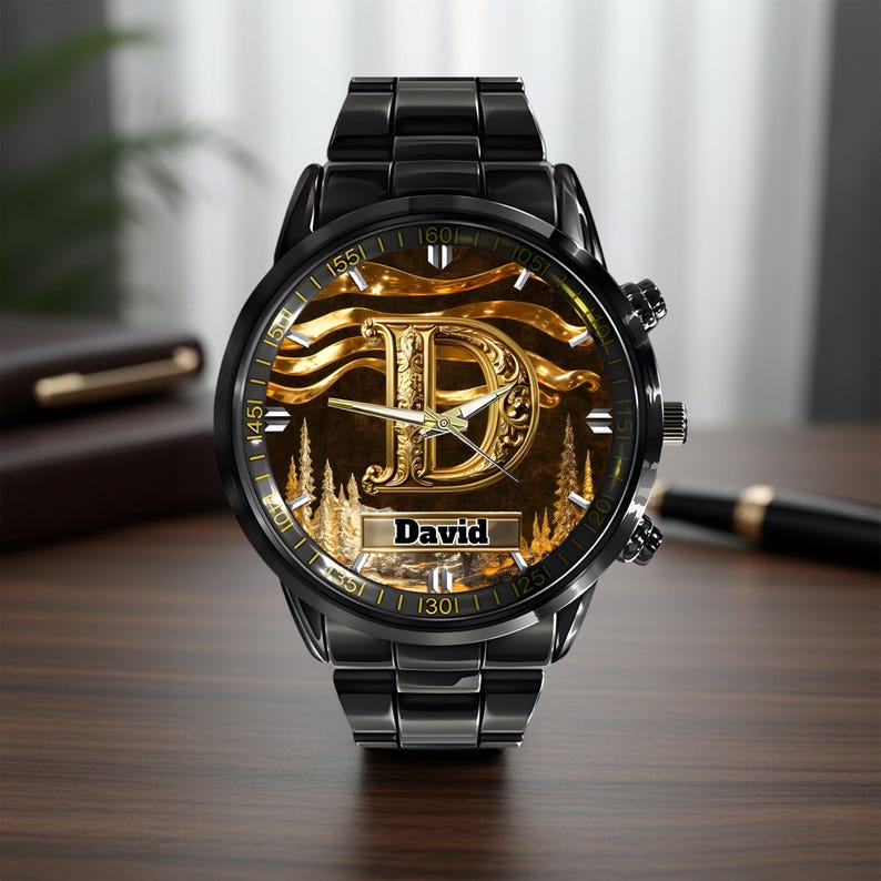 K&ouml;nnte beinhalten: Eine schwarze Armbanduhr mit einem goldfarbenen Zifferblatt mit dem Buchstaben "D" und dem Namen "David". Die Uhr hat ein schwarzes Metallarmband und eine goldfarbene L&uuml;nette. Das Zifferblatt hat ein goldenes und braunes Landschaftsdesign.