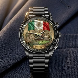 May include: A black wristwatch with a detailed face featuring the Mexican flag, a green and red design, and a gold-colored emblem. The watch has a black metal band and the name "Ricardo" is visible on the watch face.
