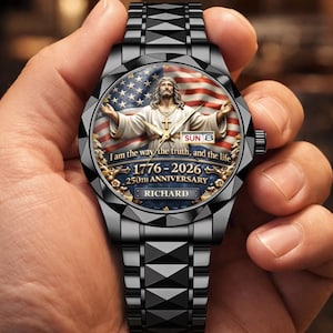 May include: Black wristwatch with a detailed face featuring an image of Jesus with the American flag in the background. The watch face includes the text "I am the way the truth, and the life" and "1776-2026 250th Anniversary". The watch band is black.