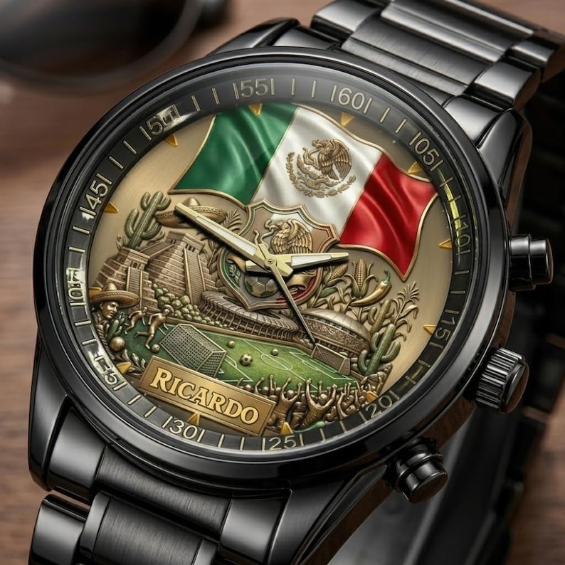 May include: Black wristwatch with a detailed face featuring the Mexican flag, a soccer stadium, and a pyramid. The watch face has gold accents and the name "RICARDO" is displayed. The watch has a black metal strap.