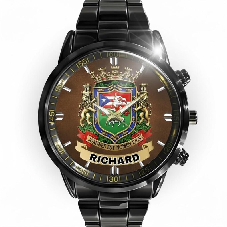 May include: Black wristwatch with a brown face featuring a coat of arms design. The watch face includes the name "RICHARD" and the phrase "JOANNES EST NOMEN EJUS". The watch has a black metal band.
