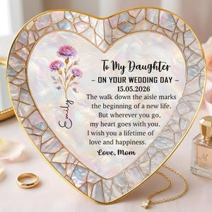 May include: Heart-shaped decorative plaque with a mother-of-pearl effect border and gold trim. The plaque features floral accents and the text "To My Daughter - ON YOUR WEDDING DAY - 15.05.2026". A gold ring and necklace are visible.