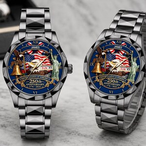 May include: Two silver-toned metal watches with dark blue faces featuring a bald eagle, the Statue of Liberty, a Liberty Bell, and an American flag. The text reads JAMES, UNITED STATES OF AMERICA, 250th ANNIVERSARY, 1776-2026, and SUN 8.