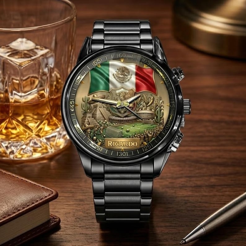 May include: Black wristwatch with a detailed face featuring the Mexican flag and a landscape scene. The watch has a black metal strap and a gold-toned face. The name "Ricardo" is printed on the watch face.