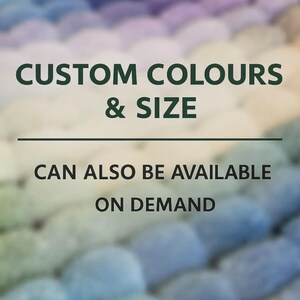 Op de afbeelding: Een getextureerd oppervlak bestaande uit talloze kleine, afgeronde, viltachtige bolletjes in een verloop van blauwe, paarse en witte tinten. De tekst luidt: CUSTOM COLOURS & SIZE CAN ALSO BE AVAILABLE ON DEMAND, met een horizontale scheidingslijn.