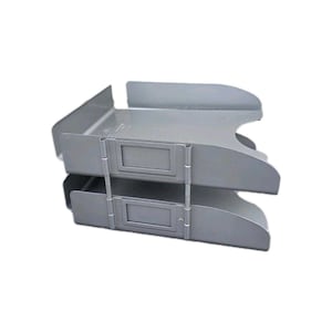 Könnte beinhalten: Ein zweistufiger, grauer Schreibtisch-Organizer aus Metall. Jedes Fach hat eine gebogene Vorderseite und einen rechteckigen Etikettenhalter. Die Fächer sind durch Metallstützen verbunden. Für den Bürogebrauch konzipiert.