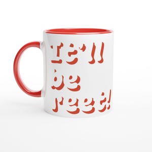 Peut inclure: Mug en céramique blanche avec intérieur et anse rouges. Le mug porte l'inscription "I'll be real!" en rouge, avec des lettres stylisées. Le mug est conçu pour les boissons chaudes.