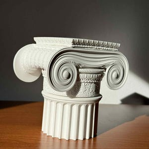 May include: A white, intricately detailed Ionic column capital. The architectural element features a scrolled volute design, fluted column, and decorative carvings. The capital is a classic representation of Greek architecture, perfect for home decor or architectural enthusiasts.