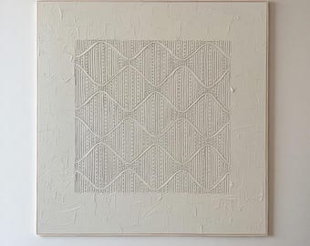 Op de afbeelding: Een groot vierkant wandkunstwerk met een crèmekleurig, gestructureerd oppervlak en een centraal paneel met verhoogde, herhalende golfpatronen en verticale stippellijnen. Het kunstwerk is ingelijst in een dunne, lichtgekleurde houten rand.