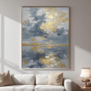May include: Abstract landscape painting with a gold frame. The artwork depicts a seascape with a cloudy sky and gold leaf accents. The color palette includes shades of gray, blue, and gold, creating a serene and reflective atmosphere.