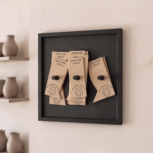 May include: A black square wall-mounted display board featuring several tan-coloured pottery ribs labelled with model numbers like GP041 RIB 140mm, GP015 RIB 100mm, GP012 RIB 100mm, and GP038 RIB 100mm, each marked with The Great Potter logo and a black knob.