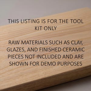 May include: A light-colored wooden surface with text in black. The text reads: "THIS LISTING IS FOR THE TOOL KIT ONLY. RAW MATERIALS SUCH AS CLAY, GLAZES, AND FINISHED CERAMIC PIECES NOT INCLUDED AND ARE SHOWN FOR DEMO PURPOSES."