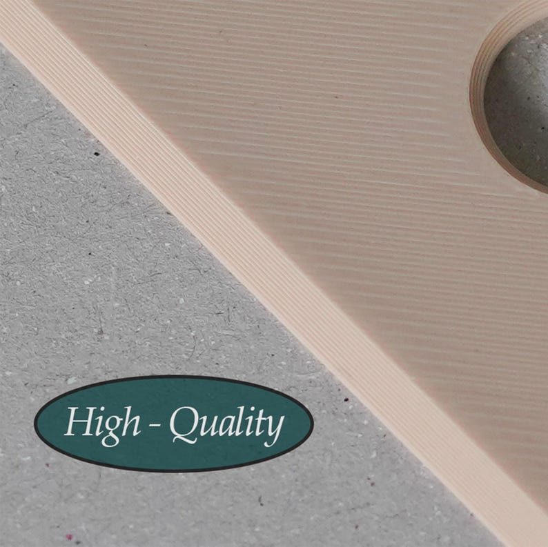 Puede incluir: Una tabla de madera de color beige claro con capas, una superficie lisa con l&iacute;neas diagonales y un recorte circular. Una pegatina ovalada de color verde azulado oscuro muestra el texto blanco "High-Quality" en fuente serif sobre un fondo gris.
