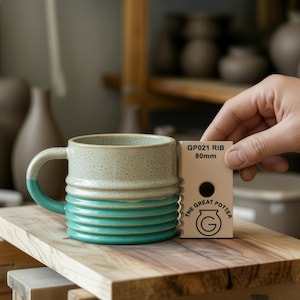 Op de afbeelding: Een set van drie keramische mokken met een gespikkelde, matte afwerking. De mokken zijn in de kleuren crème, lichtbruin en donkerbruin. Elke mok heeft een eenvoudig, minimalistisch ontwerp en een afgeronde handgreep.