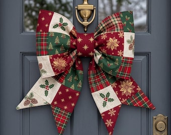 May include: A large fabric bow featuring a patchwork design of red, green, and cream squares. The pattern includes printed motifs of Christmas trees, poinsettias, holly leaves, pinecones, and gold stars. The bow is attached to a brass door knocker.