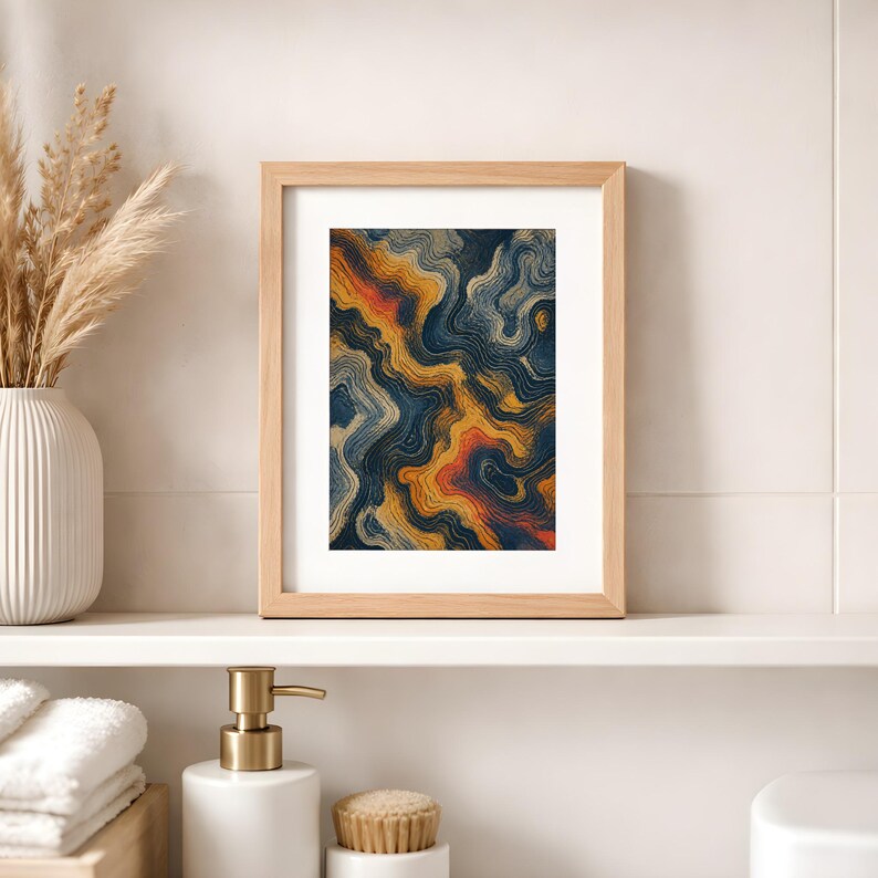 May include: A rectangular wooden frame containing an abstract print with flowing, wavy lines in shades of deep navy blue, golden yellow, and burnt orange, set against a white mat board within the frame's light-colored wood border.