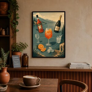 Może przedstawiać: Oprawiony wydruk artystyczny z ilustracją przepisu na koktajl Aperol Spritz. Grafika przedstawia butelkę Aperolu, butelkę Prosecco, kieliszek z pomarańczowym koktajlem, kostki lodu oraz plasterki pomarańczy na tle malowniczego jeziora.
