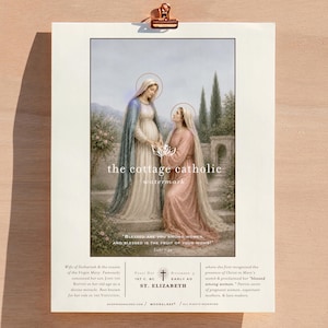 Puede incluir: Una impresi&oacute;n religiosa que presenta a dos mujeres con t&uacute;nicas y halos, en un entorno de jard&iacute;n. El texto "the cottage catholic" y una cita de Lucas son visibles. La impresi&oacute;n est&aacute; sujeta por un clip de color cobre.