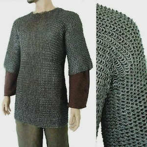 May include: A chainmail shirt with short sleeves and a crew neck. The shirt is made of small, interlocking metal rings. The sleeves are brown and extend to the mid-forearm. The shirt is worn over a brown garment.