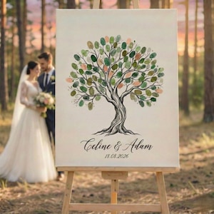 May include: A wedding guest book alternative featuring a tree design with green, pink, and peach-colored fingerprint leaves. The names "Celine & Adam" and the date "18.08.2026" are written below the tree. The canvas is displayed on a wooden easel.