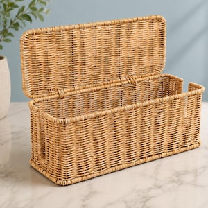 May include: A rectangular woven wicker storage basket with a hinged lid. The basket features a light tan natural finish and a vertical cutout opening on the front side. The structure is made of tightly woven reeds with a sturdy base and frame.
