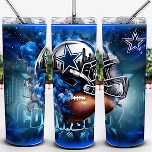 May include: A set of three stainless steel tumblers with a blue and white design. The design features a football helmet, a football, and the Dallas Cowboys star logo. The word "COWBOYS" is also visible.