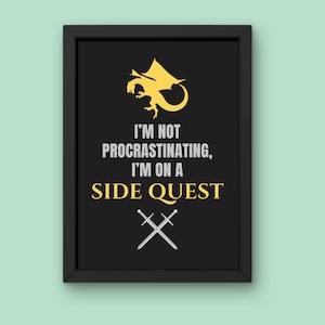 May include: Black framed print with the text "I'M NOT PROCRASTINATING, I'M ON A SIDE QUEST". The print features a gold dragon illustration above the text and crossed swords below. The background is black.